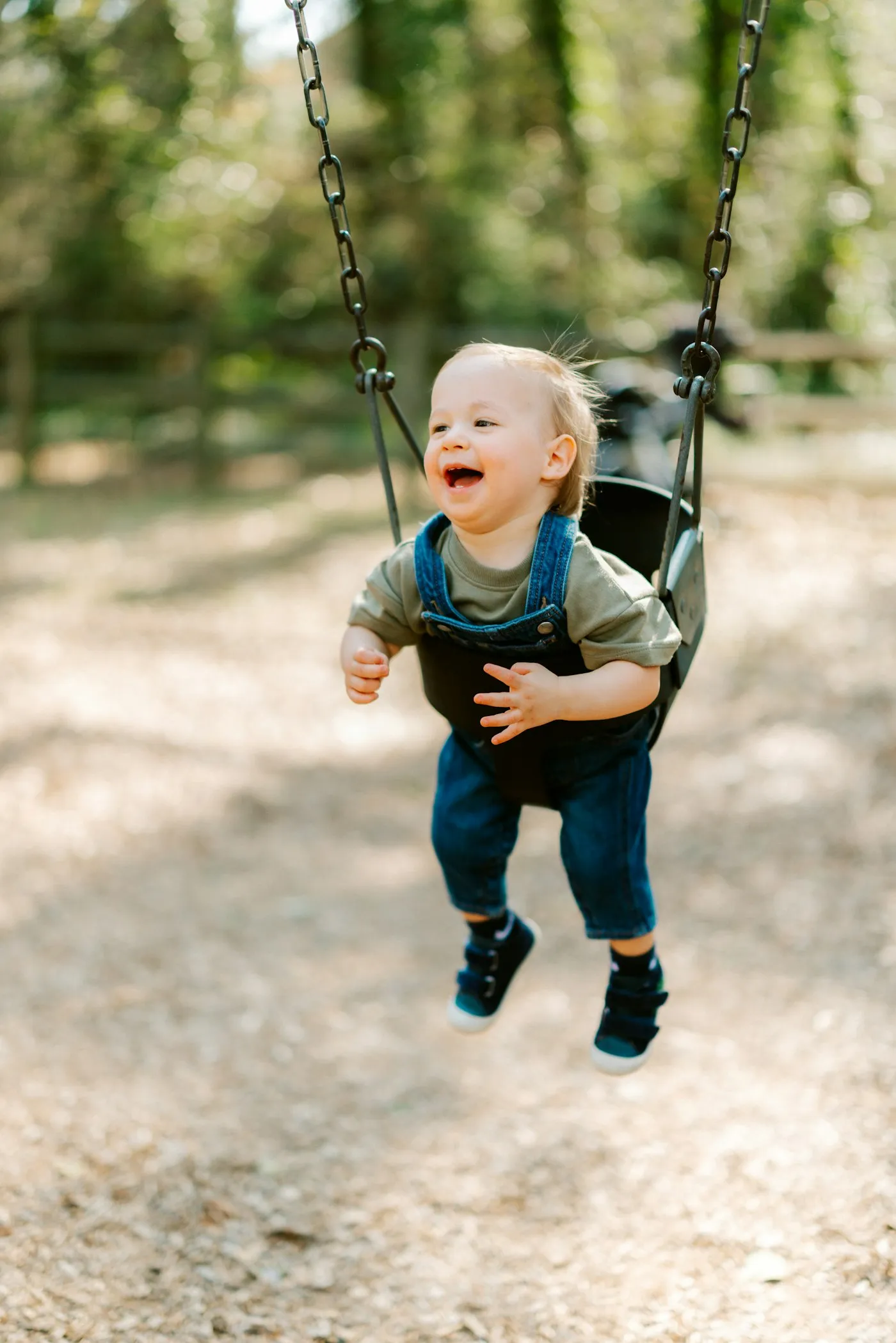 A baby laughing on a swing