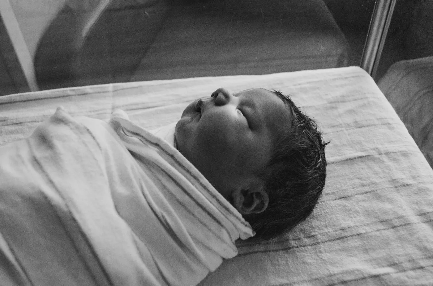 A newborn asleep, wrapped in a blanket